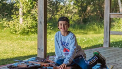 camper sitting and smiling at the Rifle Range